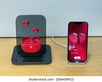 Cologne, Germany - October 28th 2021: A german photographer visiting an apple store, comparing different beats in-ear headphones for his iPhone.