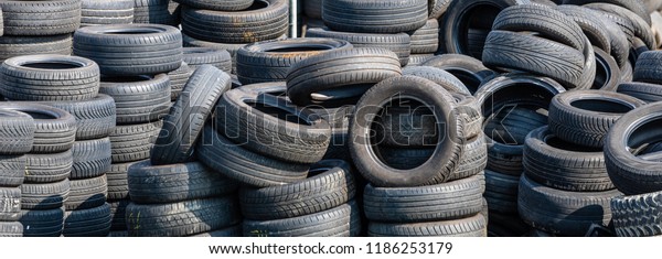 Cologne, Germany -\
September 2 2018: Used tires, stacked in a junkyard. The rubber\
will be recycled in noise protection walls or used in the\
incinerators of the cement\
industry.