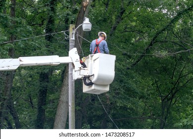 Coloma MI USA July 2, 2019 an electrical worker in a boom truck, fixes a street light at a local park