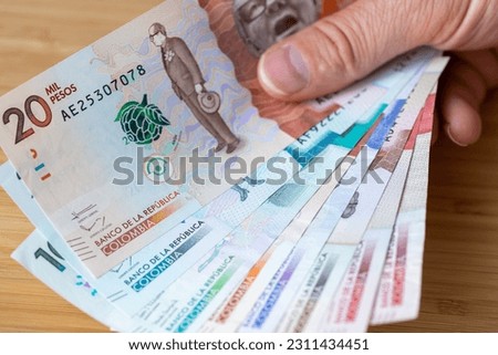 Colombia, Bundle of pesos banknotes held in hands, Financial concept, Columbian business success
