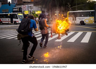 MEDELLÍN, COLOMBIA - MAY 03, 2021: A young man carries a burning object to barricade the street. Days of protests in Medellin against the tax reform and President Ivan Duque.