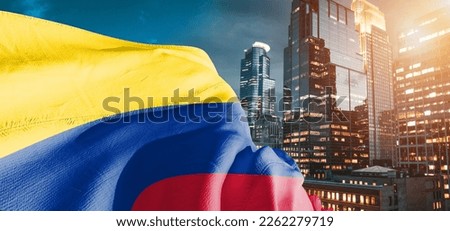 Colombia national flag cloth fabric waving on beautiful buildings background.
