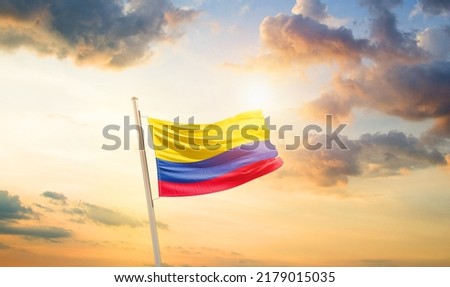 Colombia national flag waving in beautiful clouds.