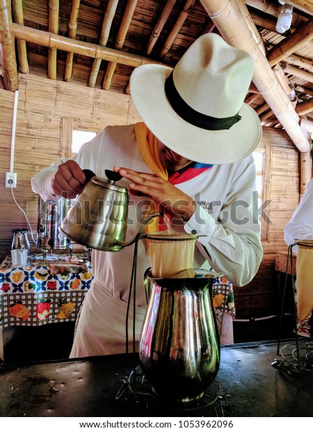 A colombian barista preparing\
a fresh cup of coffee at the coffee farm in Quindio,\
Colombia.