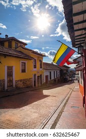 The Colombian Flag Flies Over A Cobblestone Street In The Candelaria Neighborhood Of Bogota, Colombia.