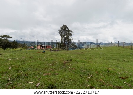 Colombian green and blue mountains landscae with a country farm house