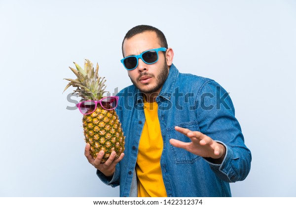 colombian-man-holding-pineapple-sunglasses-600w-1422312374.jpg