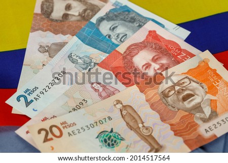 Colombian pesos against the background of national colors 