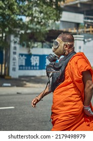 Colombo, Sri Lanka - July 09 2022: A Buddhist monk wearing a gas mask to protect from tear gas attacks by the Sri Lanka police walks toward an anti-government protest