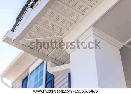 Colonial white custom porch columns with wood looking vinyl column wrap, sheets and molding, white soffit provides optimal ventilation for roof overhangs 
