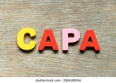 Color alphabet letter in word CAPA (abbreviation of corrective action and preventive action) on wood background