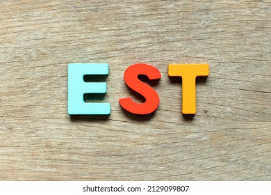 Color Alphabet Letter In Word EST  (abbreviation Of Established, Estimated, Eastern Time Zone, Expressed Sequence Tag) On Wood Background
