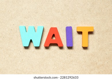 Color alphabet letter in word wait on wood background