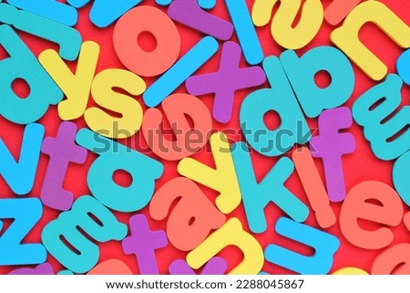 Color alphabet letters on red background. World Dyslexia Day concept. Solving the educational problem of reading. Medical and mental health awareness. Logopedy, psychology, learning lessons