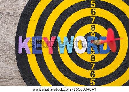 Color alphabets KEYWORD on dartsboard background with red arrow hit center of target. Advertising business and marketing concept. Keyword research is important SEO activity if would like page to rank.