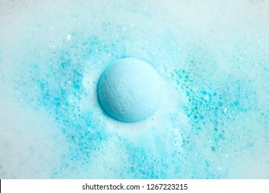 Color bath bomb dissolving in water, top view