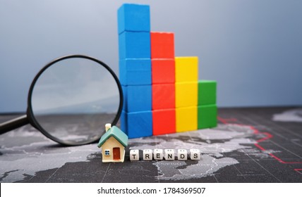 Color Block Stacking As 3D Graphs With Word TRENDS And Miniature House. Business Strategy Concept Of Real Estate Downward Trends From Economic Crisis Or Housing Market Crash Due To Coronavirus Impact.