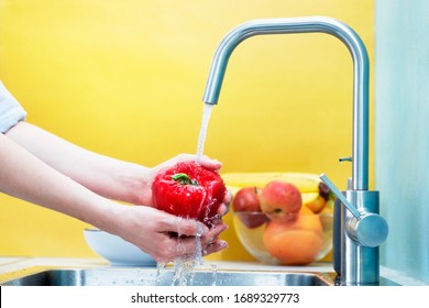 Color and bright shot as a young woman thoroughly washes vegetables in the kitchen. Vegetable preparing to eat you need to wash - Powered by Shutterstock