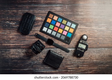 Color Checker, Flash meter , watch watch, 50mm lens on a wood background surface topview