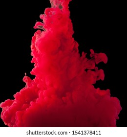 Color cloud of paint. Acrylic ink spreads in water. Colored red abstraction is isolated on a black background. Close up.