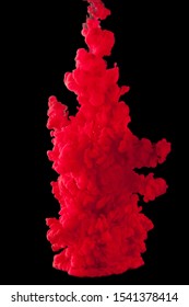 Color cloud of paint. Acrylic ink spreads in water. Colored red abstraction is isolated on a black background. Close up.