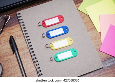 Color Coded Key Chains On A Spiral Bound Notebook. 