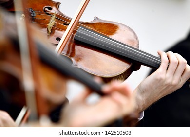 Color detail with the hands of a person playing the violin