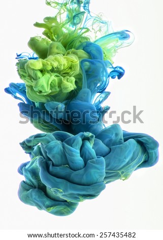 Color drop in water, photographed in motion. Ink swirling in water. Cloud of silky ink in water isolated on white background. Colorful ink in water, ink drop. Action painting.