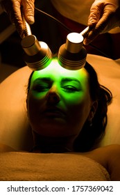 Color Effect On The Skin.Led Light Therapy.Chromotherapy Procedure With Hydrafacial Device.Woman Doing LED Face Therapy In Green