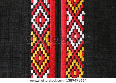 Color embroidery on black fabric. National Turkmen patterns in traditional colors are red, yellow, white.