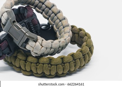 The color green red black and grey multifunction paracord survival bracelet over white background. - Powered by Shutterstock