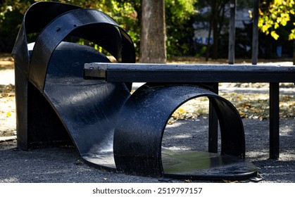 Color horizontal photo, metal sculpture of a woman's sandal on a heel, decoration of a park bench in a public park. - Powered by Shutterstock