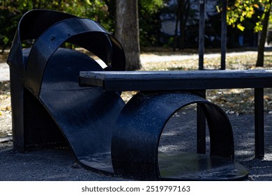 Color horizontal photo, metal sculpture of a woman's sandal on a heel, decoration of a park bench in a public park. - Powered by Shutterstock