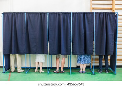 Farbbild einiger Wähler in einigen Wahlkabinen eines Wahlsenders.