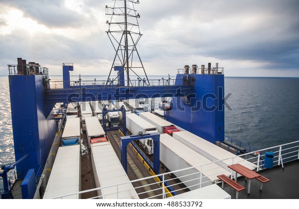 Color image of some trucks loaded on the deck of a\
ferry boat.