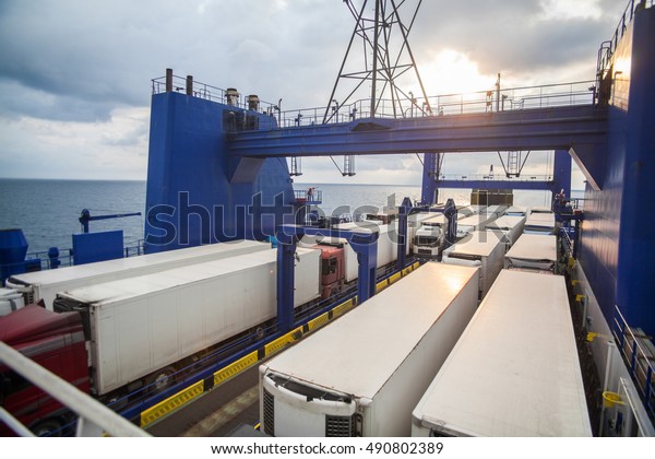 Color image of some trucks loaded on the deck of a\
ferry boat.