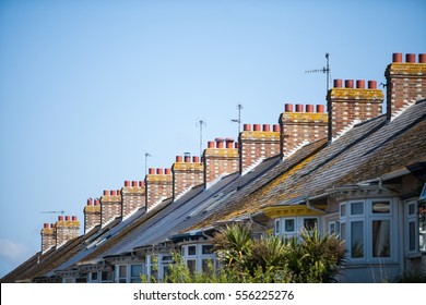 Color image of a typical English row of houses with chimneys.