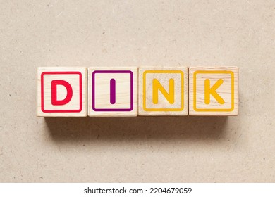 Color letter block in word DINK (Abbreviation of Double income, no kids or Dual income, no kids) on wood background