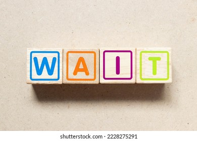 Color letter block in word wait on wood background