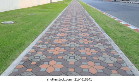 color Long paved brick footpath, Brick path or sidewalk with perspective going into the distance, abstract background of tiles, footpath, sidewalk in landscape orientation.