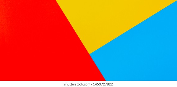 Color papers geometry flat composition background with yellow red and blue tones
