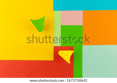 Color papers geometry flat composition background with rainbow tones and two paper plane