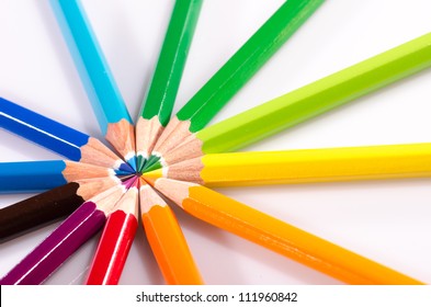 Color pencils arranged in roygbiv on white background