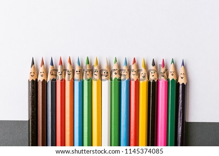 Color pencils with faces painted on them. the concept of a multinational family and equality in the world.