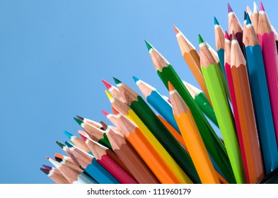 Color pencils isolated on blue background close up