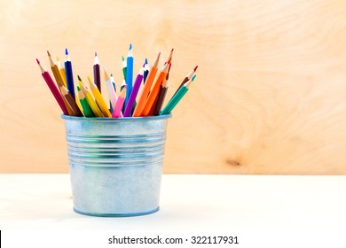 Color pencils in tin can, on a wood table - Powered by Shutterstock