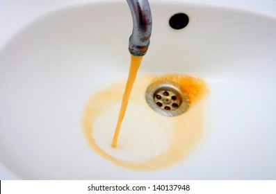 Color photography of a rusty water what run from a faucet
