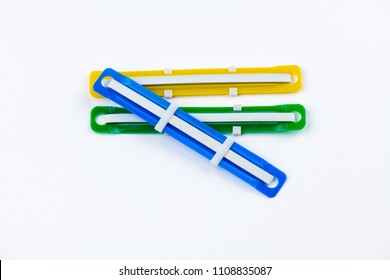 Color Plastic Paper Fastener.Office Paper Is A Plastic Tongue On White Background.