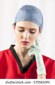 Color Portrait Of Beautiful Female Doctor Wearing Scrubs And Theater Scrub Cap With Gloves, Posing In Front Of A White Background With A Serious Facial Expression