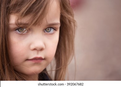 Color Portrait Of A Little Girl With Big Sad Eyes